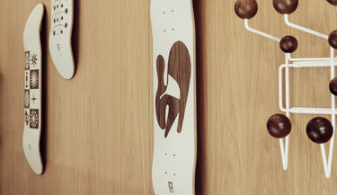 Lifestyle shot of the eames x globe collab skateboard decks hanging on a wall 