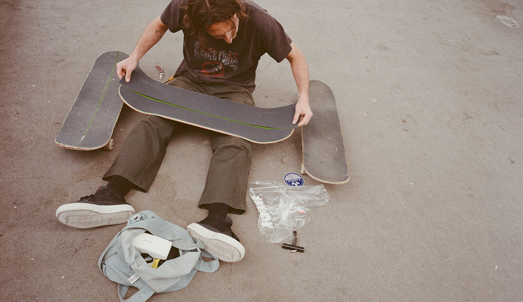Lifestyle shot of model setting up skateboard 