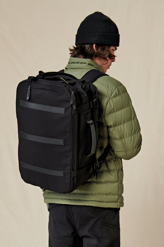 model wearing Globe Black 3 in 1 traveler bag